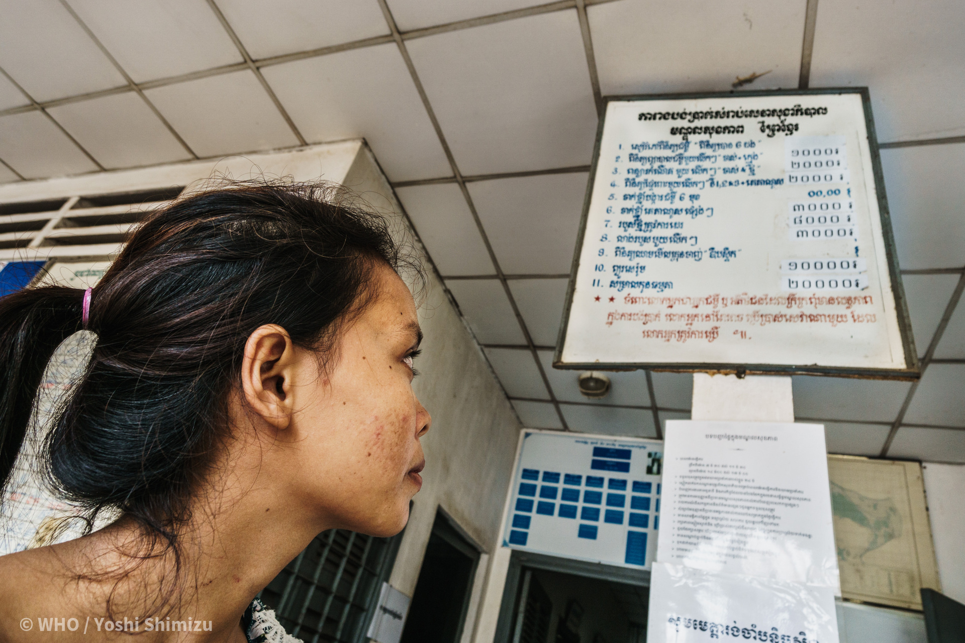 A female patient in the clinic looks at the information board