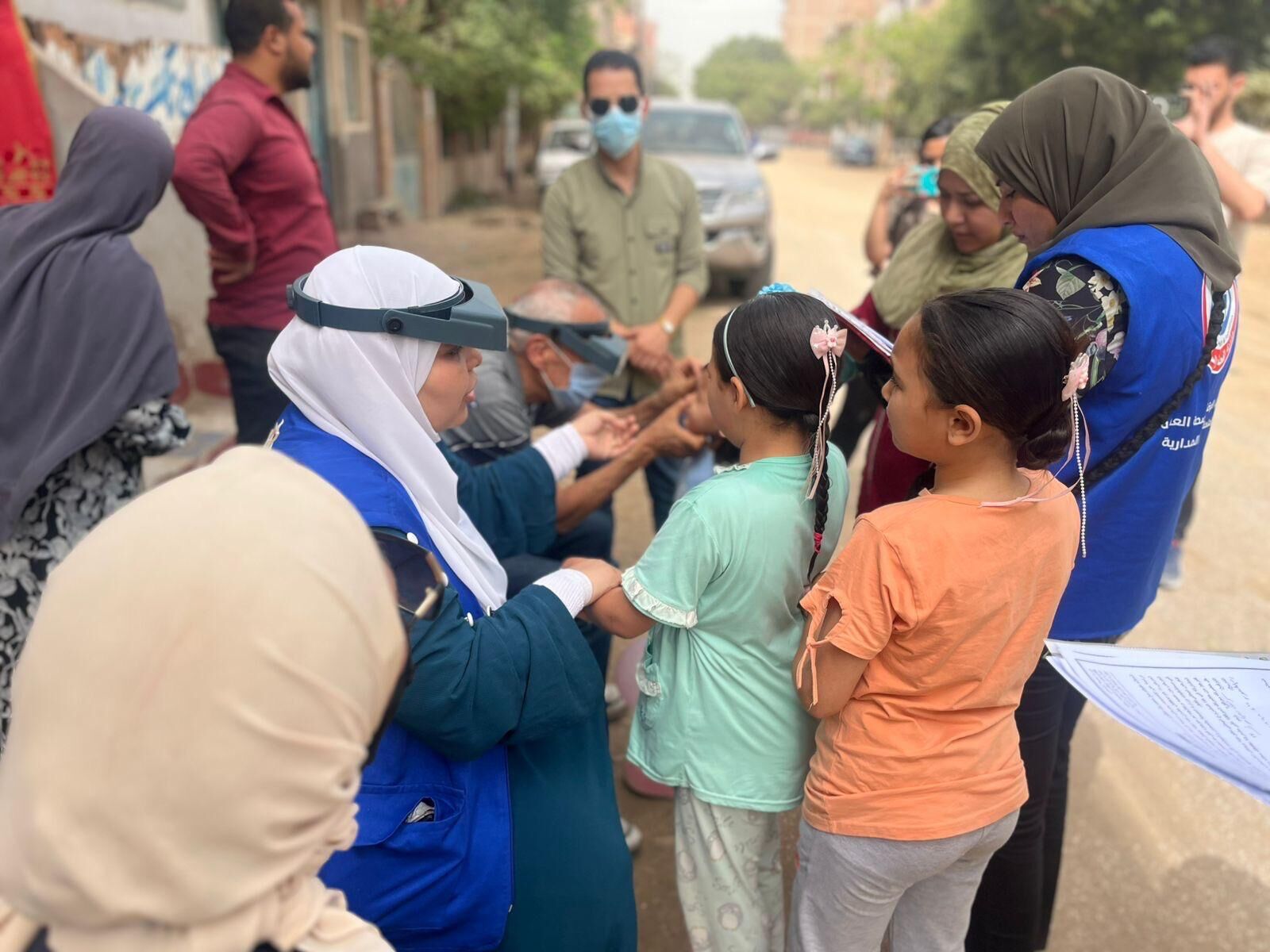 Health care worker checks childrens eyes